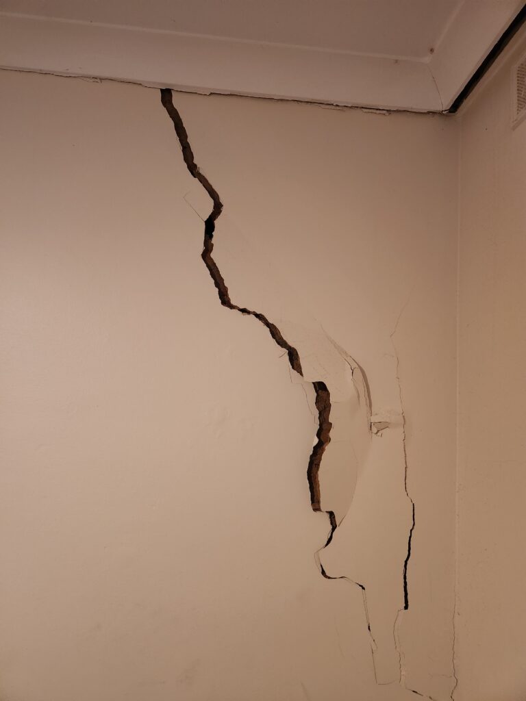 Image showing a wall crack with a hole, included in a smart structural report.