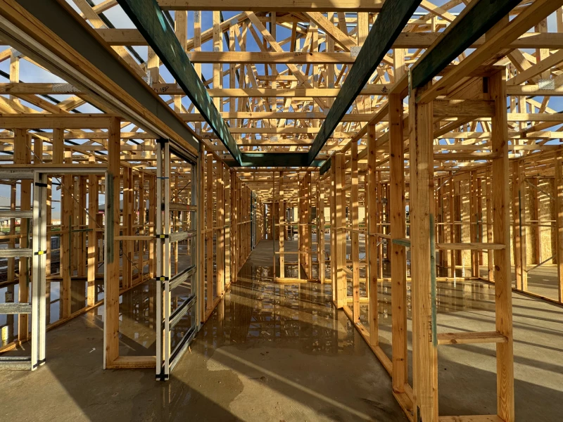 House under construction featuring wooden framing, showcasing its structural design and progress in building.