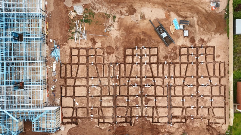 Overhead image of a construction site, coverage and equipment actively engaged in site preparation.